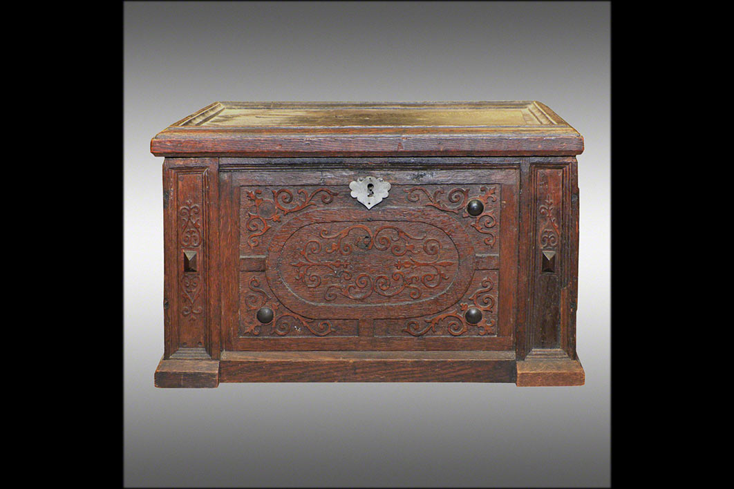 aus Eichenholz mit Ornamentauflagen aus Ahornholz und NussbaumVorzustand: Profile waren unsachgemäß erneuert; Fehlstellen in der Ornamentik, im<br>Holz u. bei den Beschlägen; Kratzer, Risse u. Dellen, nicht originaler Oberflächenbezug